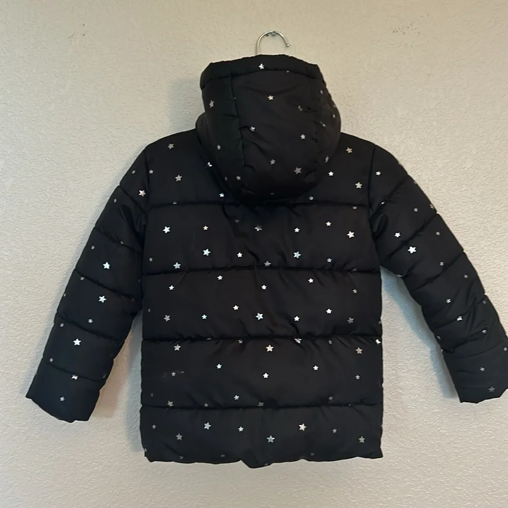 Girls hooded winter coat size XS (4/5) in black with silver stars.